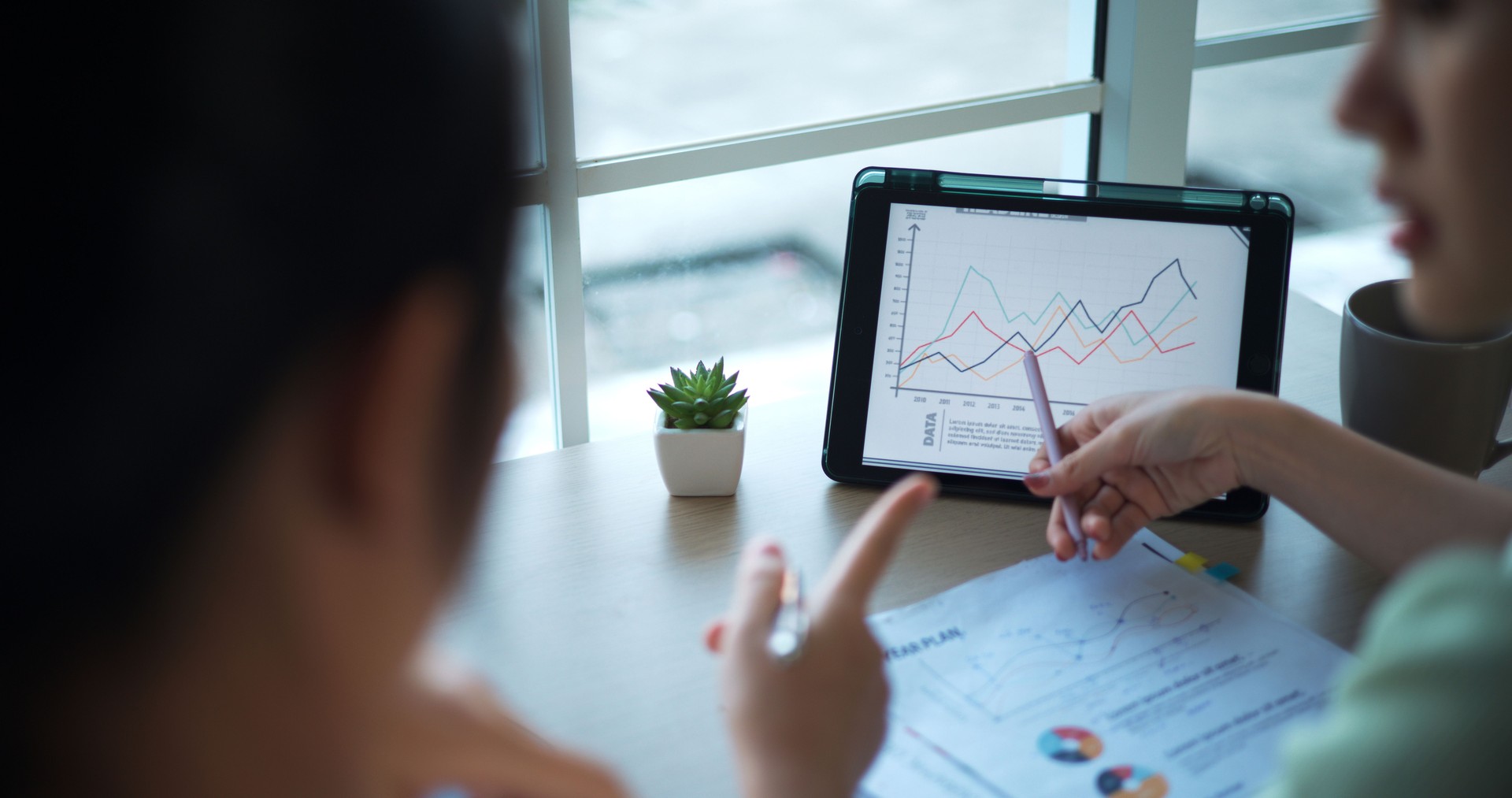 Asian confident financial advisor use tablet explaining details of investing